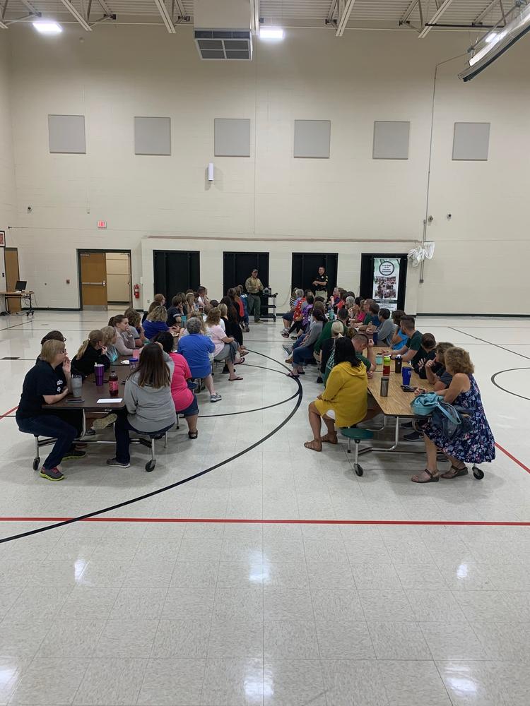children sitting at large table watching active shooter training